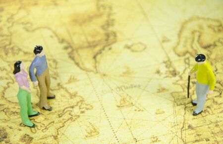 mini model of a man woman and oldman on a old world map