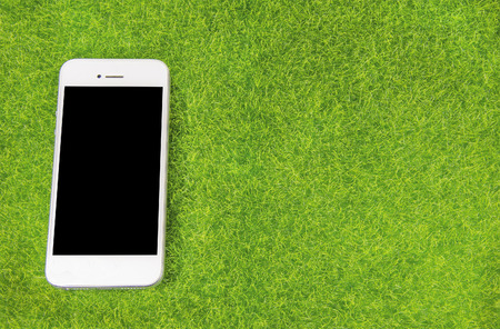 Smart phone on a grass fieldの写真素材