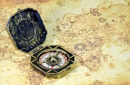 compass and pirate golden coin on a old world map