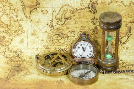 old compass and hourglass on a old world mapの写真素材
