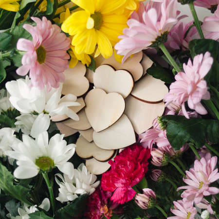 Wooden hearts surrounded with colorful flowers. Natural concept. Flat lay.の写真素材