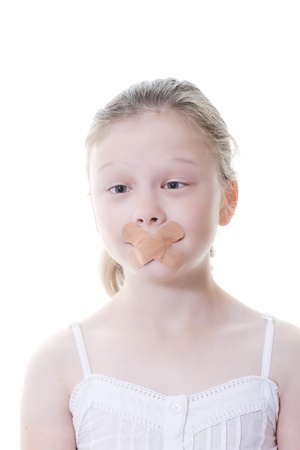 preteen girl with sticking plaster across her mouthの写真素材