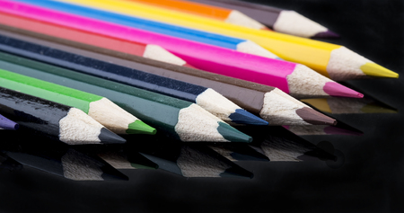collection of sharp color pencils with reflection on black backgroundの写真素材