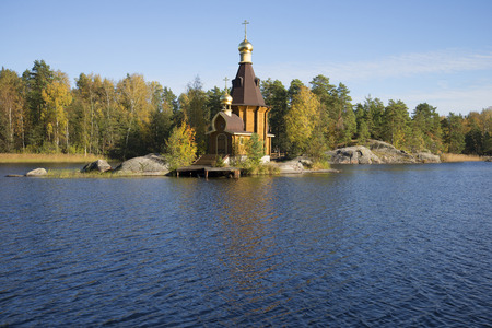 View of the wooden church of St. Andrew on the River Vuoksi sunny october day, Russiaの写真素材