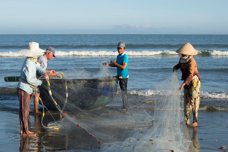 DA NANG, VIETNAM - JANUARY 04, 2016: Fishermen dismantle the network before going out to sea