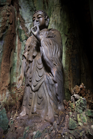 Sculpture of standing Buddha in the cave Tang Chon in the Marble mountains. Da Nang, Vietnamの写真素材