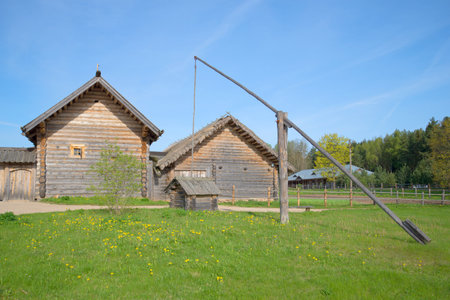 PSKOV REGION, RUSSIA - MAY 08, 2016: Ancient well on wooden farmhouses. Reconstruction of a farm of the XVIII century in the village Bugrovo. Pushkin Hillsのeditorial素材