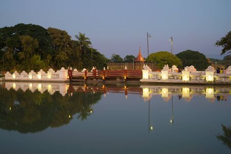 Old bridge in the twilight. The historic centre of Mandalay, Myanmarの写真素材