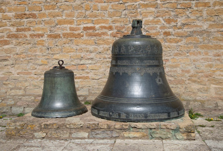 Two vintage bell against the wall of the castle of Herman. Narva, Estoniaのeditorial素材