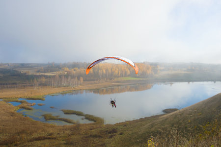 IZBORSK, RUSSIA - OCTOBER 21, 2017: Flight on a motor paraplane above the Gorodischensky Lakeのeditorial素材