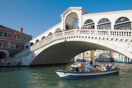 VENICE, ITALY - SEPTEMBER 25, 2017: The commercial boat sails under the Rialto bridgeのeditorial素材
