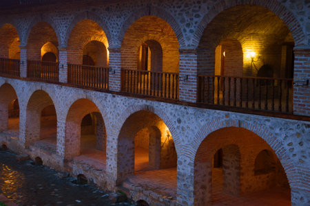 Fragment of the gallery of the building of an ancient caravanserai in the evening twilight. Sheki,...