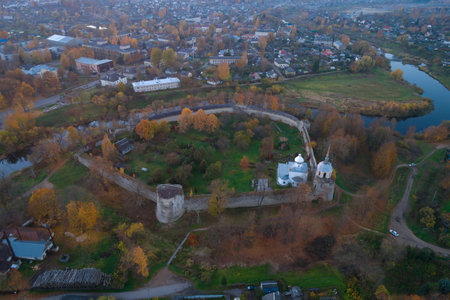 The ancient fortress in the cityscape on October evening (shooting from a quadrocopter). Porkhov,...