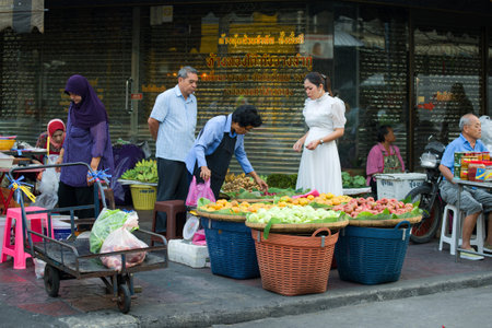 BANGKOK, THAILAND - DECEMBER 27, 2018: An elderly woman sells fruit in a street marketのeditorial素材