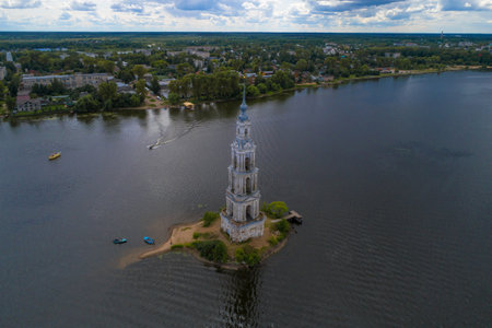 The ancient flooded bell tower against the background of the cityscape on a cloudy July day. Kalyazin, Russiaのeditorial素材