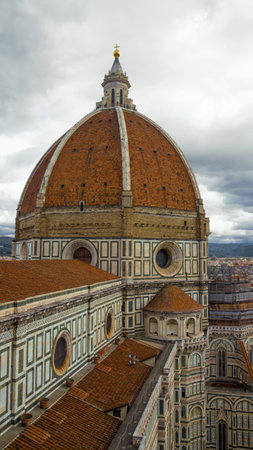 Dome of the ancient Cathedral of Santa Maria del Fiore close-up against a gloomy cloudy sky. Florence, Italyのeditorial素材