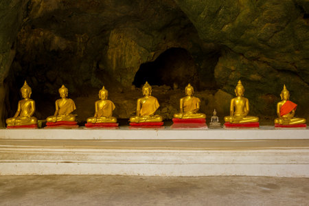 Phetchaburi, THAILAND - DECEMBER 13, 2018: Gallery with ancient sculptures of a sitting Buddha in the interior of the Wat Tham Khao Luang cave templeのeditorial素材