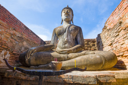 Ancient sculpture of a sitting Buddha on the ruins of a Buddhist temple Wat Si Chum. Sukhothai, Thailandのeditorial素材
