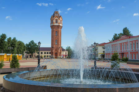 City fountain against the background of an old water tower on a sunny July morning. Staraya Russa,...