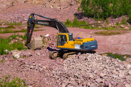 KVARTSITNYY, RUSSIA - JUNE 12, 2020: Volvo excavator in raspberry quartzite quarry