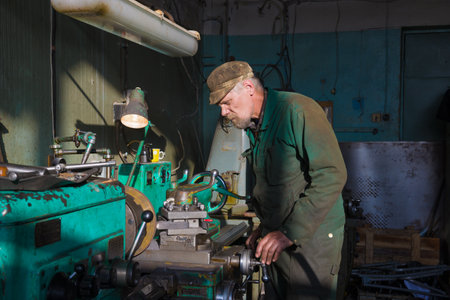 ST. PETERSBURG, RUSSIA - OCTOBER 28, 2020: Elderly turner behind a lathe