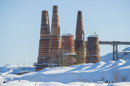 View of the ruins of lime kilns in an abandoned marble and lime factory on a sunny March afternoon....