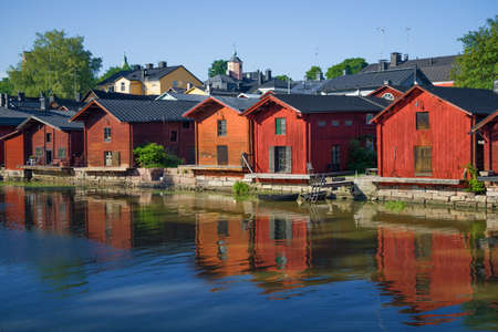 Old wooden warehouses on the banks of the Porvoonjoki river in the light of the evening sun on a summer evening. Porvoo, Finlandの写真素材
