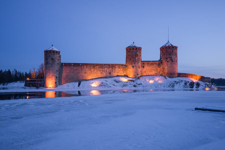 Ancient fortress Olavinlinna in night illumination on a March twilight. Savonlinna, Finlandのeditorial素材