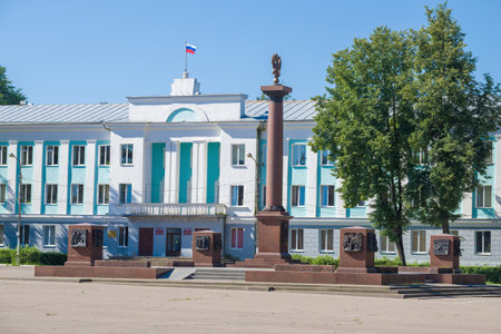 VELIKIE LUKI, RUSSIA - JULY 04, 2021: Monument "City of Military Glory" against the background of the city administration building on a sunny July morningのeditorial素材