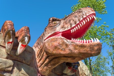 VELIKIE LUKI, RUSSIA - JULY 04, 2021: Head of a carnivorous dinosaur over the entrance to Dinopark close-up on a sunny July dayのeditorial素材