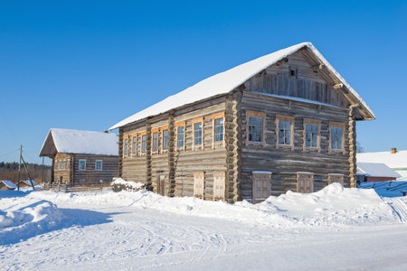 POGOST, RUSSIA - FEBRUARY 22, 2021: Ancient wooden houses of the Arkhangelsk province in the ethnographic museum "Oshevenskaya volost" on a sunny winter dayのeditorial素材