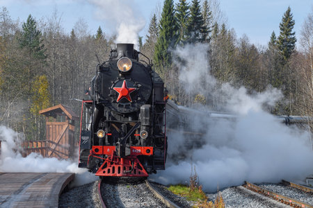RUSKEALA, RUSSIA - OCTOBER 07, 2021: The tourist retro train "Ruskeala Express" arrives on the station of Ruskeala Mountain Park on a sunny October dayのeditorial素材