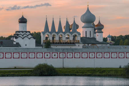 Domes of the Tikhvinsky Assumption Monastery against the background of the sunset sky. Tikhvin,...
