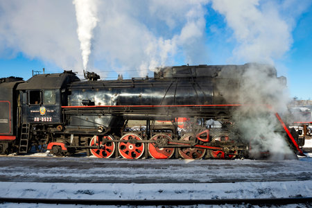 SORTAVALA, RUSSIA - MARCH 10, 2021: Old Soviet steam locomotive of the "LV" series in puffs of steam on a sunny March dayのeditorial素材