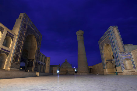 BUKHARA, UZBEKISTAN - SEPTEMBER 10, 2022: Night at the ancient Kalan madrasah and Mir-i-Arab...