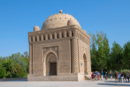 BUKHARA, UZBEKISTAN - SEPTEMBER 09, 2022: A group of tourists near the ancient mausoleum of the Samanids (IX-X centuries) on a sunny dayのeditorial素材