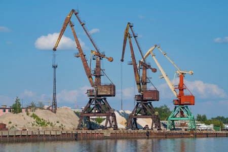 CHEREPOVETS, RUSSIA - AUGUST 04, 2022: Three port cranes in the river port on a sunny summer dayのeditorial素材