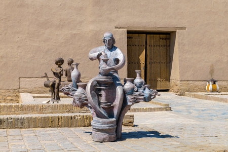 KHIVA, UZBEKISTAN - SEPTEMBER 05, 2022: Sculpture of a potter on the square of the inner city of Ichan-Kala on a sunny dayのeditorial素材