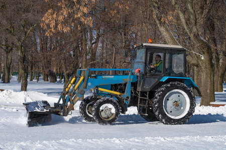 KRONSHTADT, RUSSIA - MARCH 13, 2023: Tractor MTZ-82.1 "Belarus" cleans the paths of the city park from snow on a sunny March dayのeditorial素材