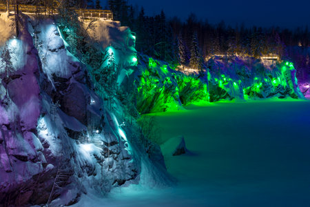 The steep wall of the Marble Canyon in multi-colored illumination on a January night. Ruskeala Mountain Park. Karelia, Russiaの写真素材