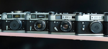 SAMARKAND, UZBEKISTAN - SEPTEMBER 12, 2022: Old Soviet cameras FED-4 and FED-5 on a shelf on a black backgroundのeditorial素材