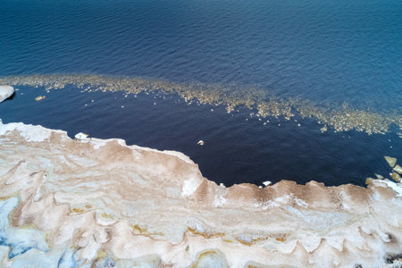 Top view of the melting snow on the shore of Ladoga Lake on a March day (aerial photography)....