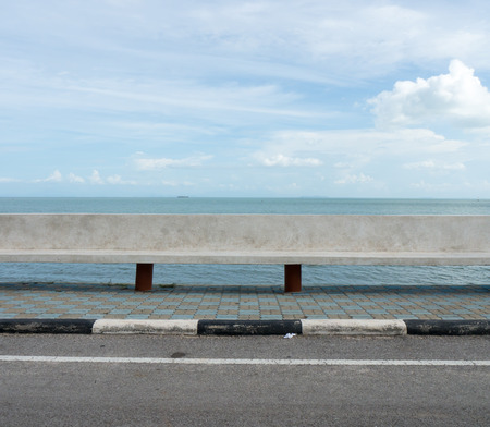 Concrete seat roadside with sea and blue sky backgroundの写真素材
