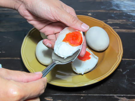 salted egg,salted duck egg on dish/spoonの写真素材