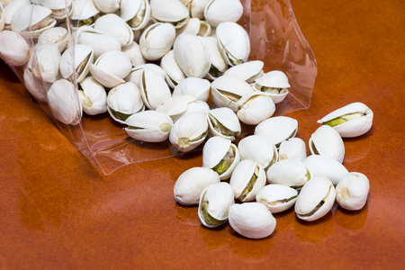 Pistachio nuts on wooden boardの写真素材