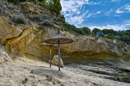 Two umbrellas on volcano rock beachの写真素材