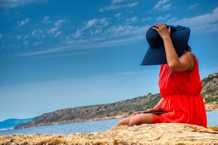 Women reading e-book on beachの写真素材