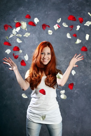a very happy and joyfully girl tossing rose petals in the airの写真素材