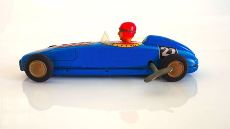 Antique toy car side view and wind up with a reflection isolate