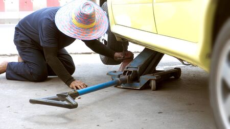 Asian man made object to rocking a trolley jacks service car tools, To change my car tire.の写真素材
